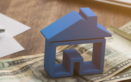 A blue cube on a pile of money.