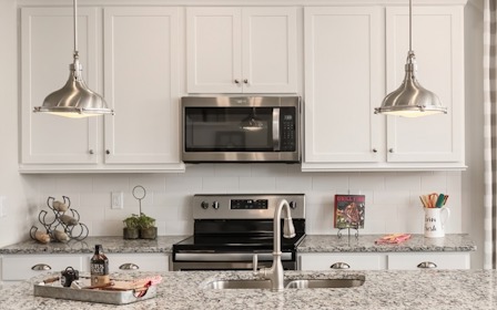 A kitchen with white cabinets.