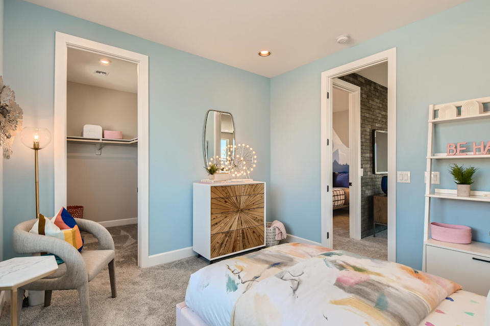 A bedroom with a bed and a chair.