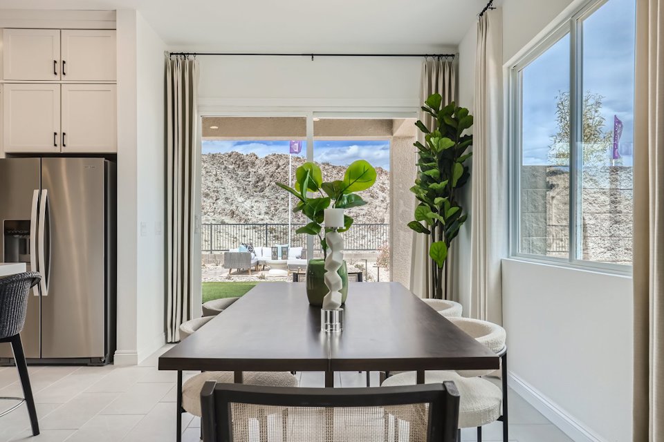 A dining table with a vase of flowers on it.