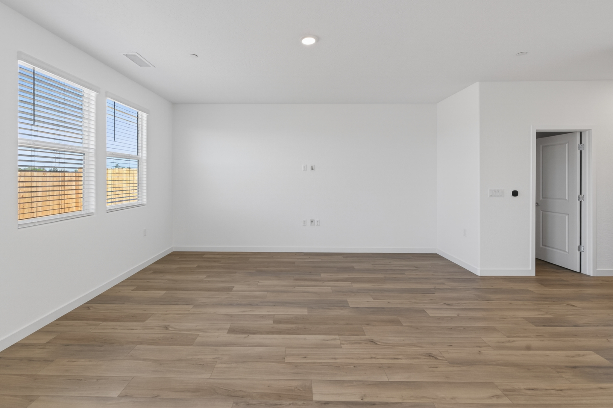 A room with a wood floor and windows.