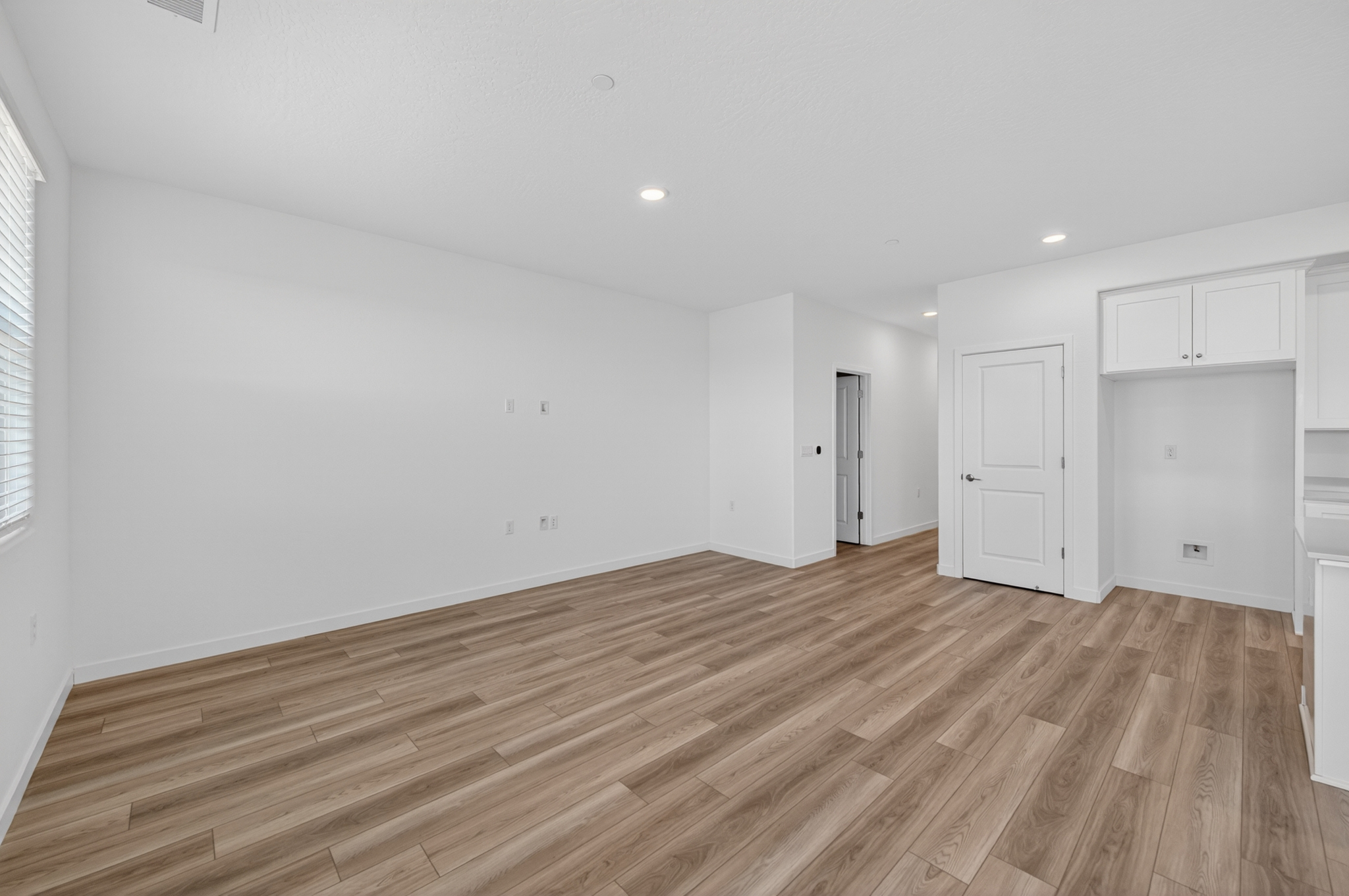 A room with white walls and wood floors.