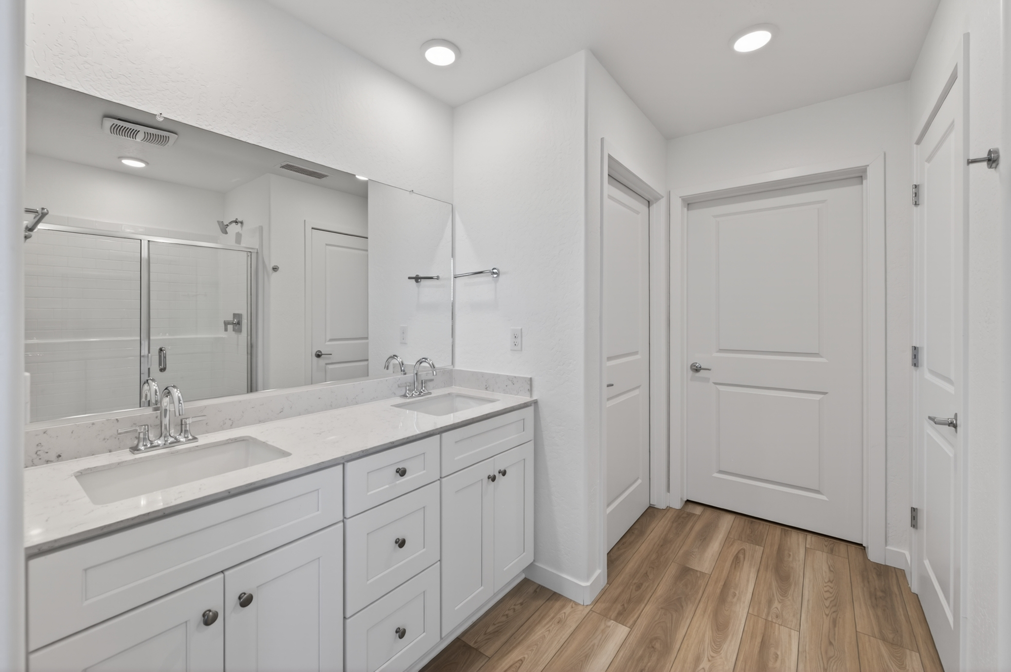 A bathroom with white cabinets.