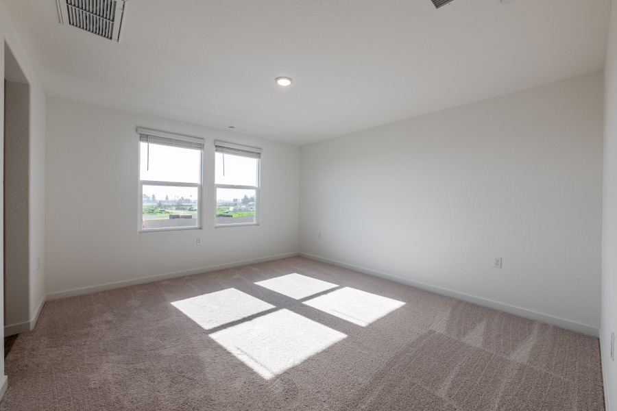 A room with a rug and windows.