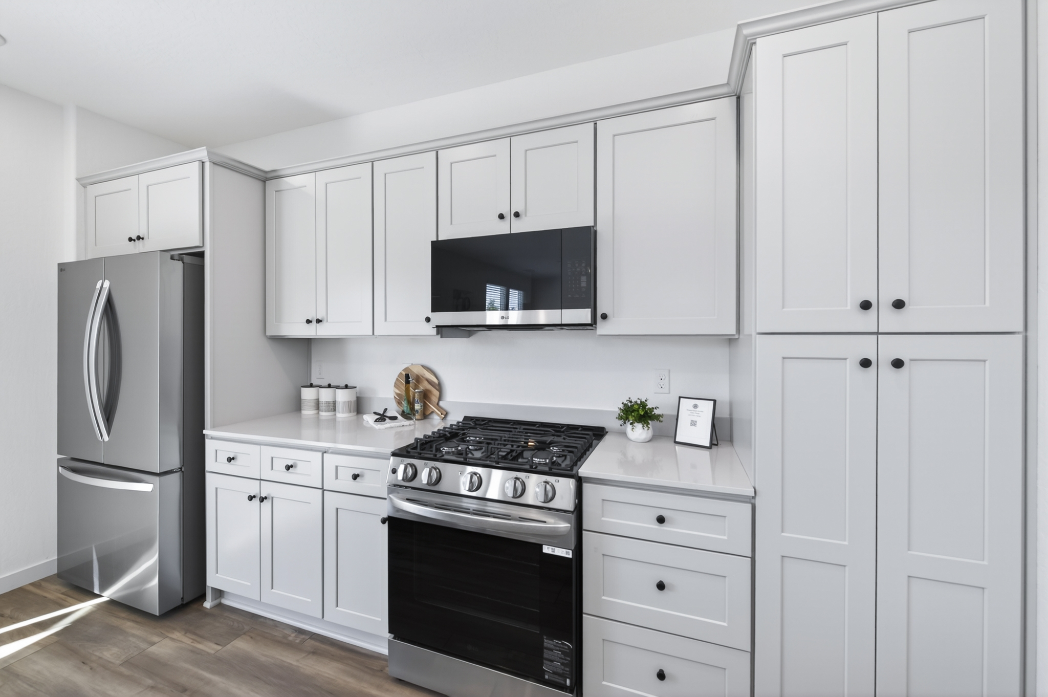 A kitchen with white cabinets.