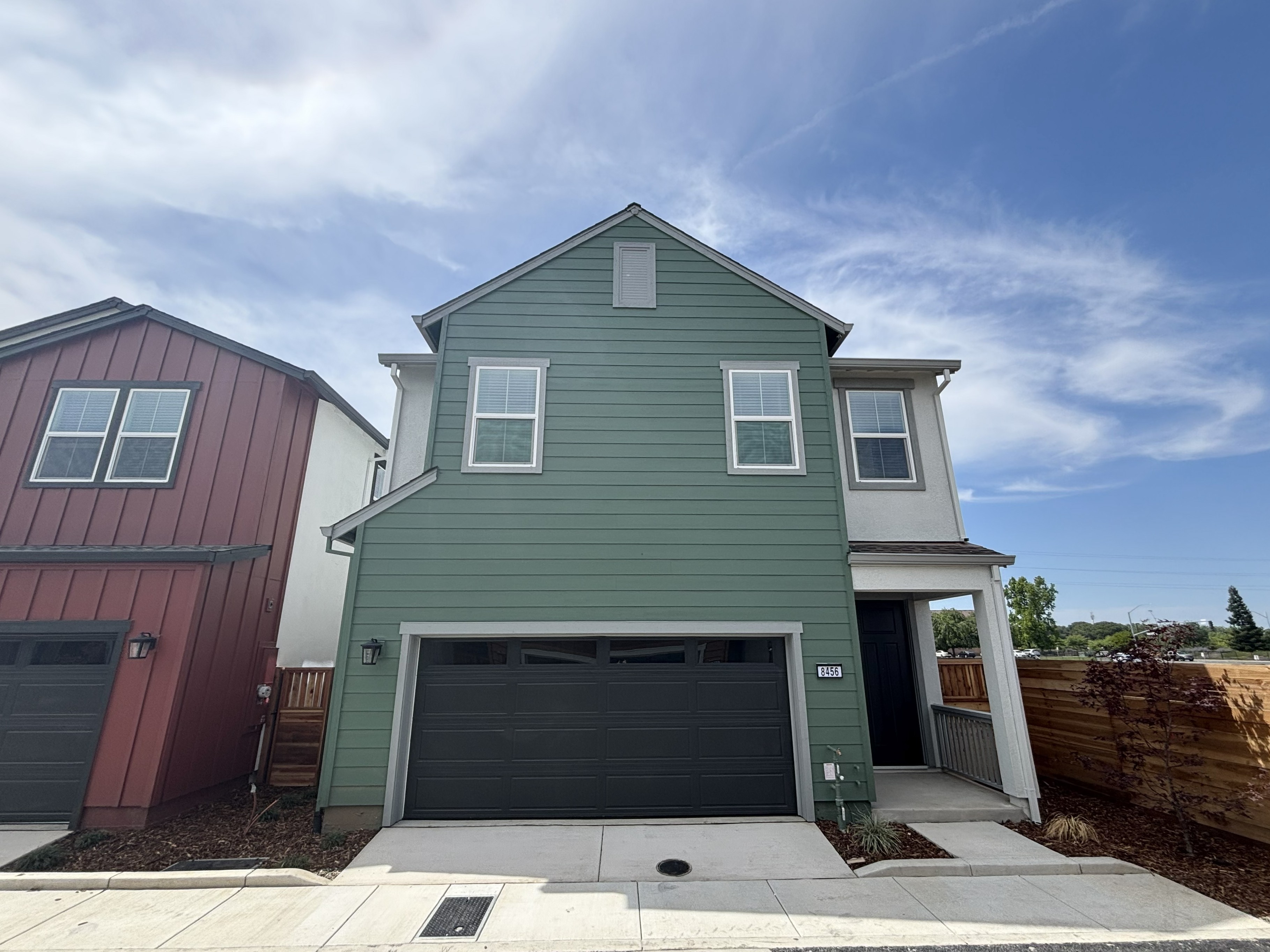 A green house with a garage.