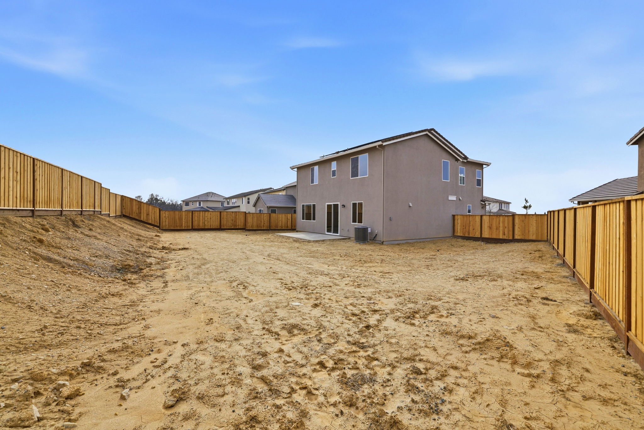 A dirt road with buildings on the side.