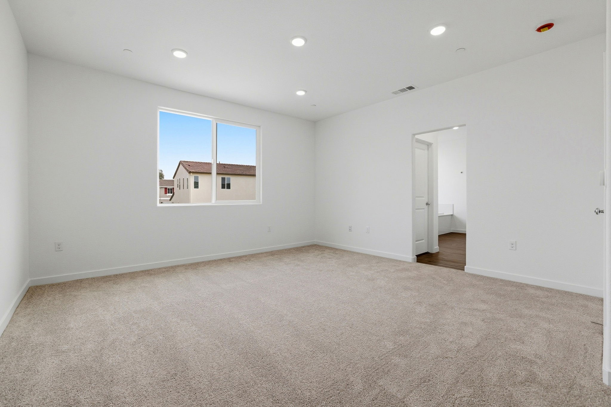 A room with a carpet and a window.