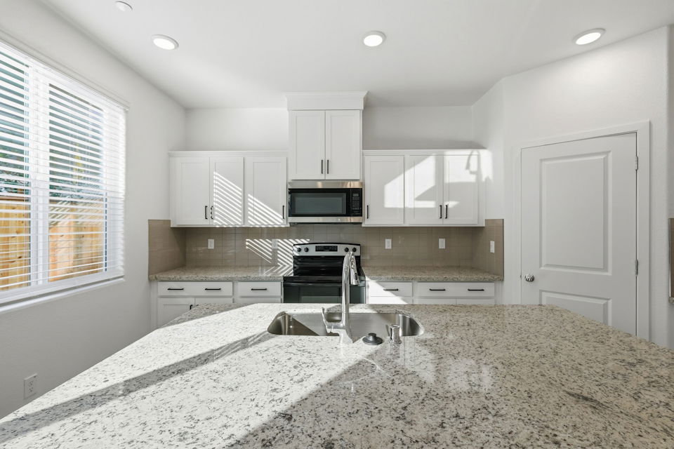 A kitchen with white cabinets.