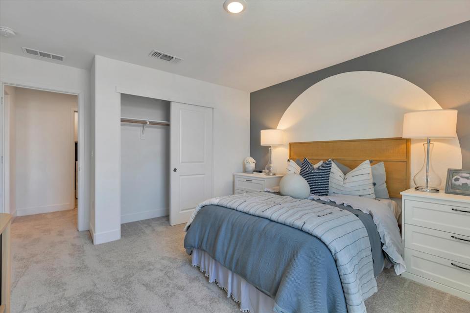 A bedroom with a bed and lamps.