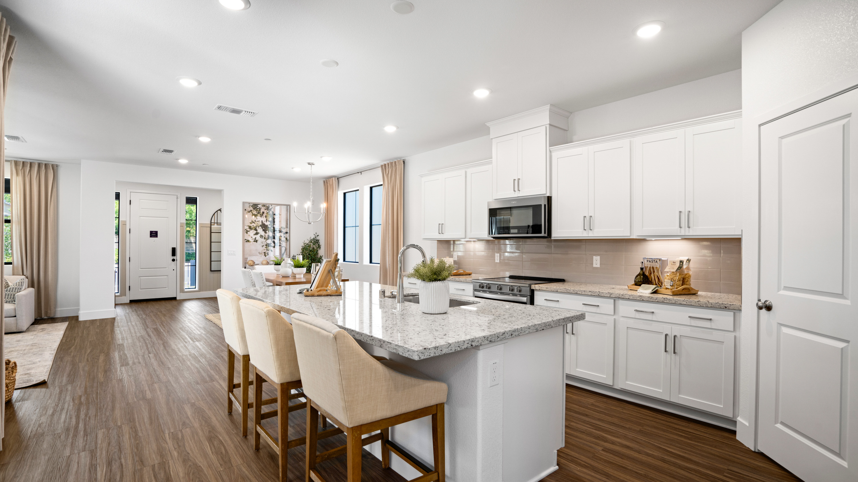 A kitchen with white cabinets.
