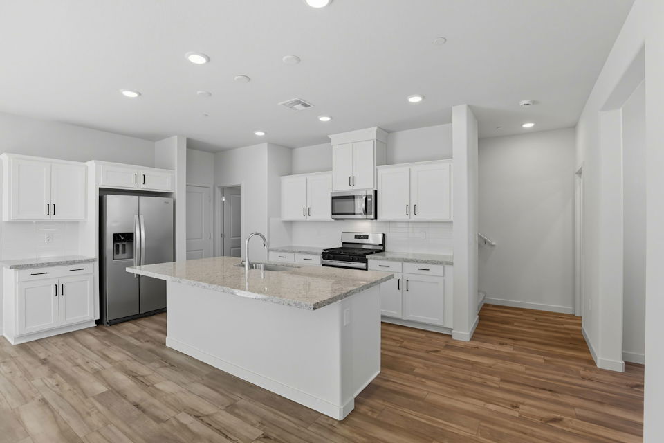 A kitchen with white cabinets.