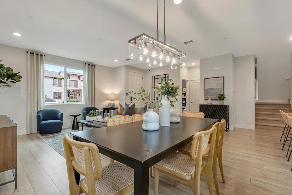 A dining room with a chandelier and a table.