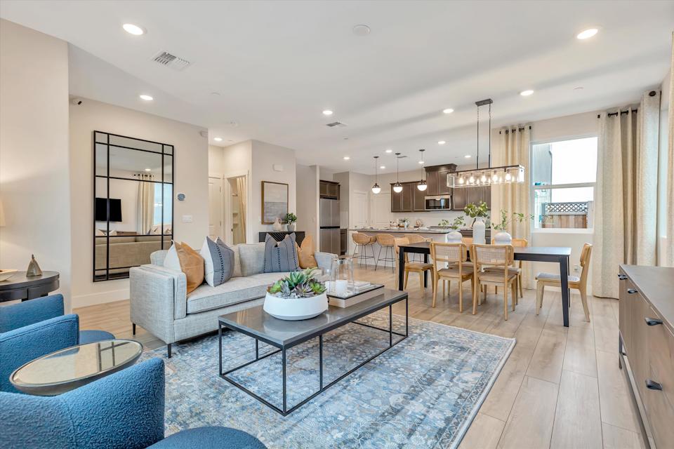 A large living room with a large dining table and a large kitchen.