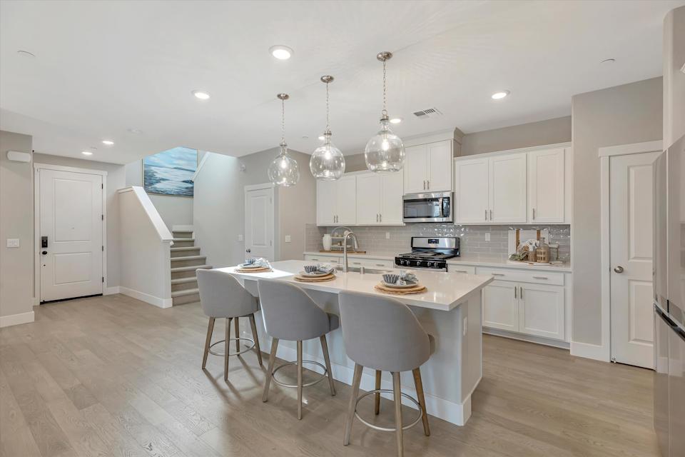 A kitchen with a table and chairs.