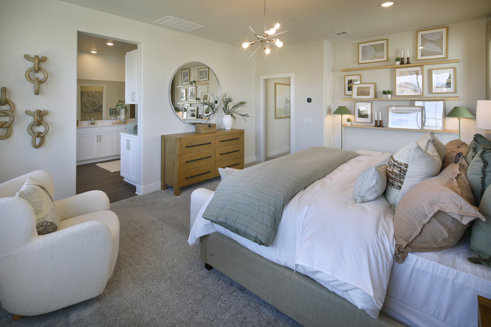 A bedroom with a bed and a chair.