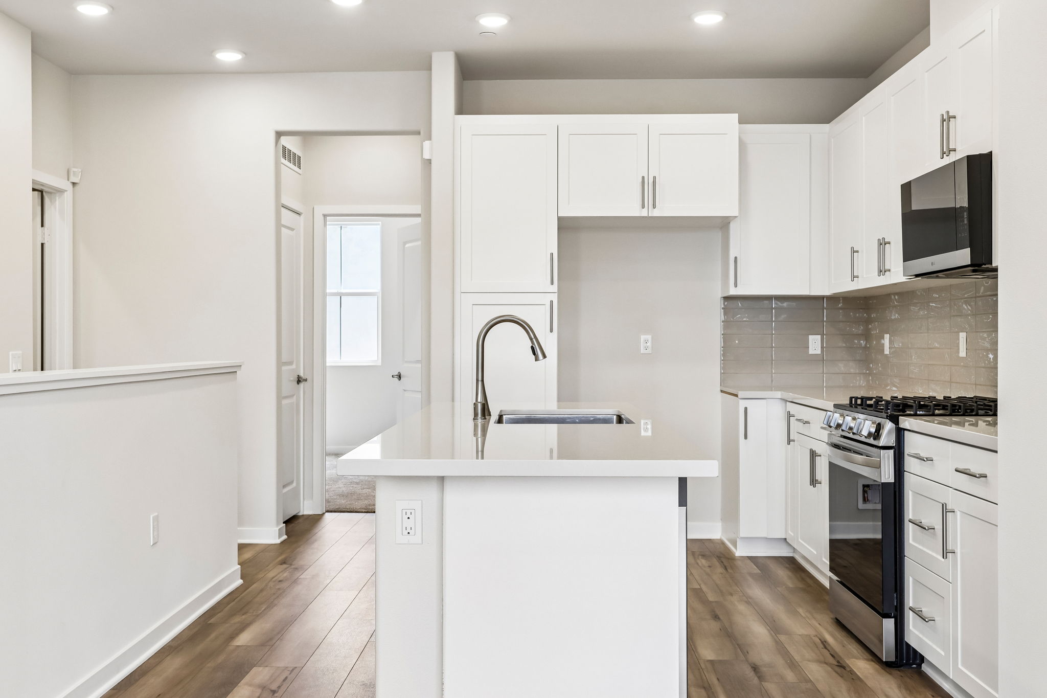 A kitchen with white cabinets.