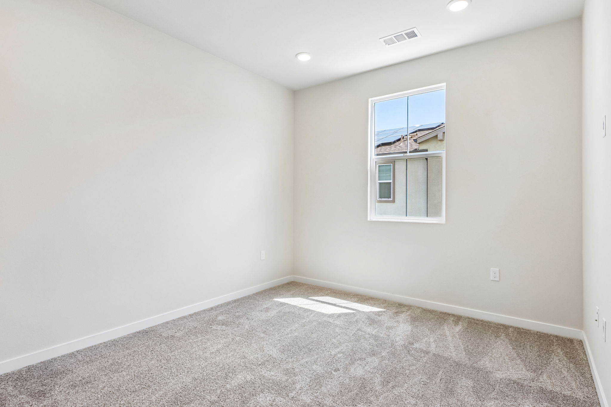 A room with a window and a rug.