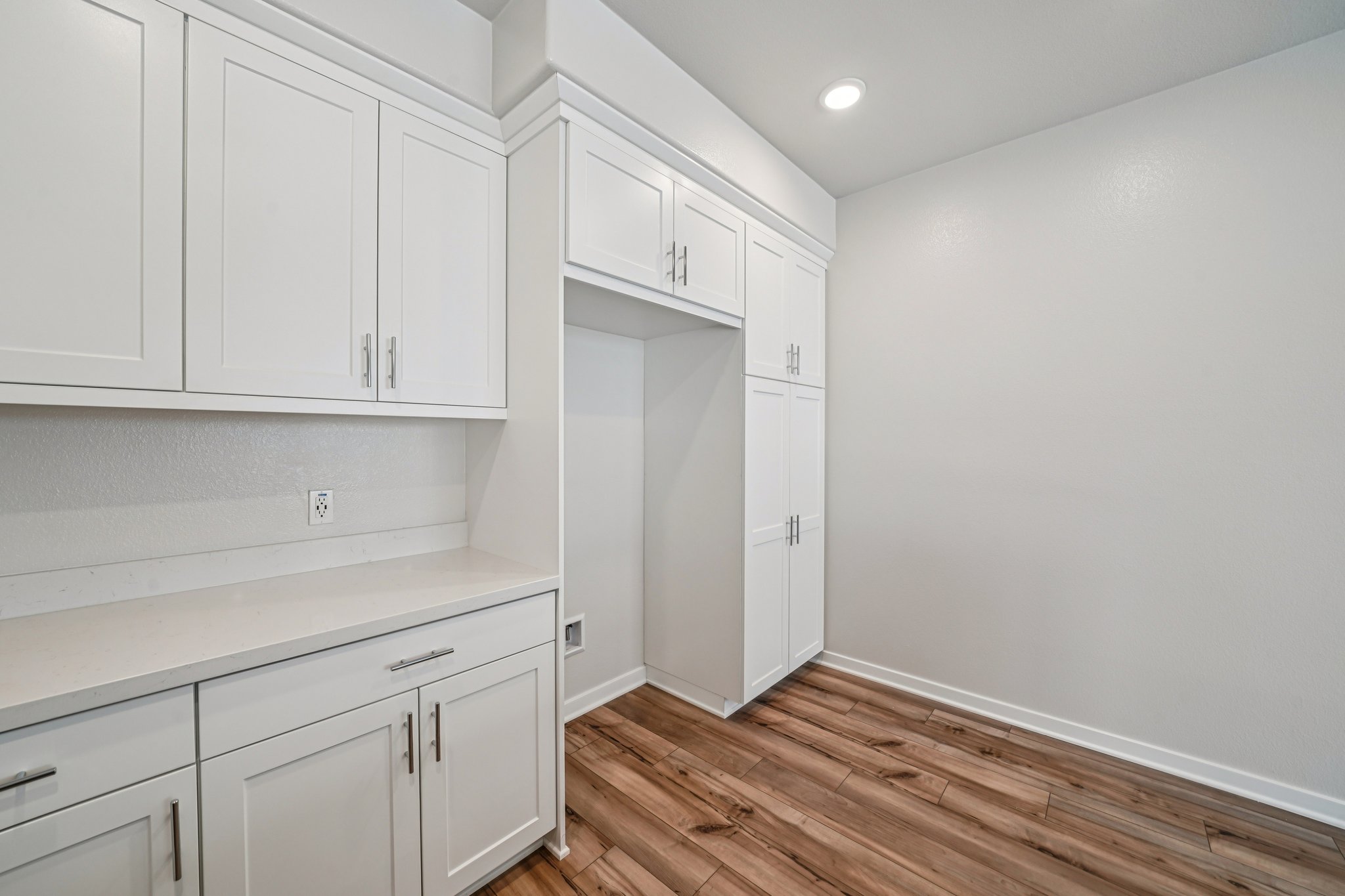 A kitchen with white cabinets.