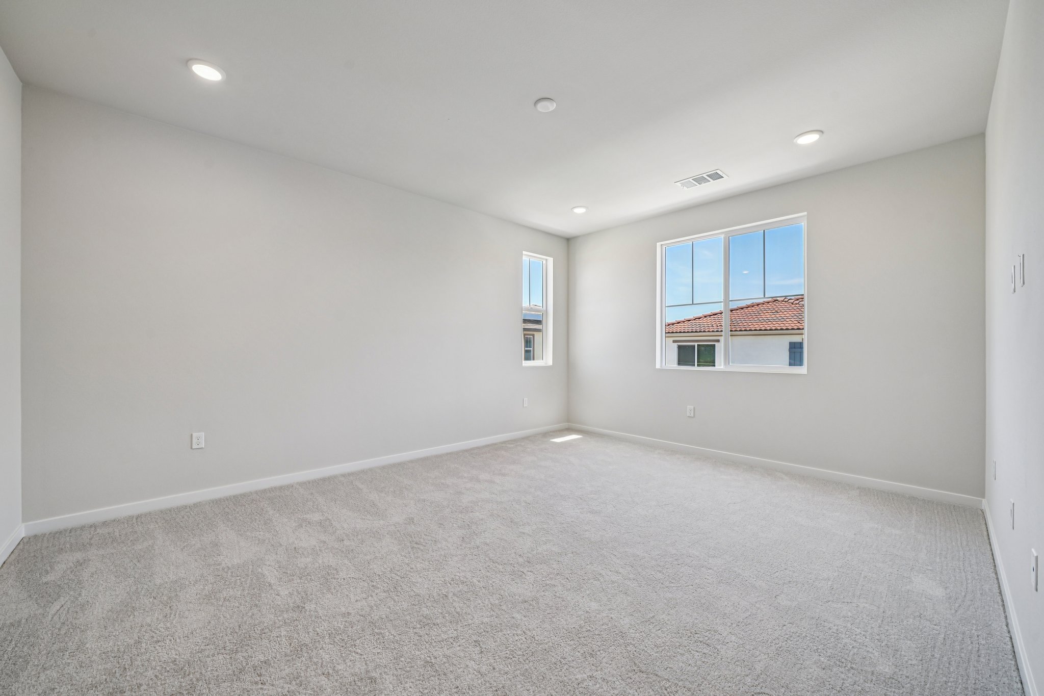 A room with a carpet and windows.