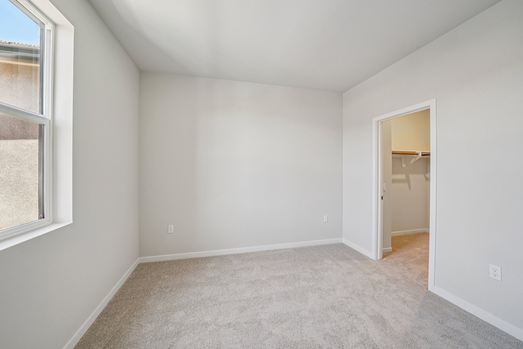 A room with a carpet and a window.