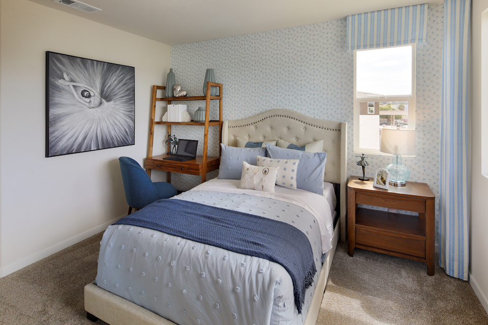 A bedroom with a bed and a desk.