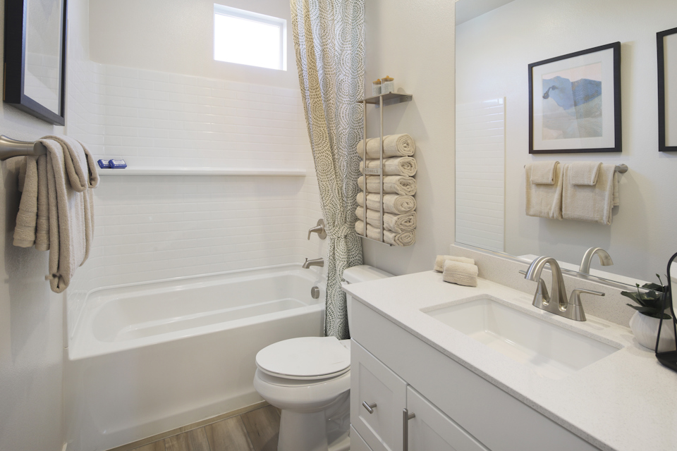A bathroom with a sink toilet and towels.