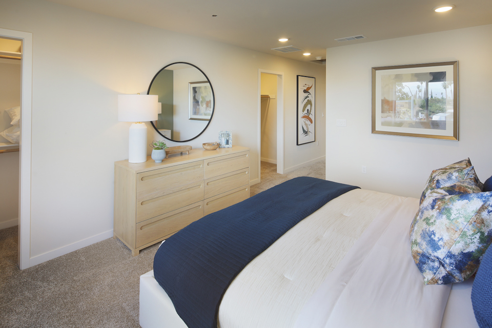 A bedroom with a bed and a mirror.