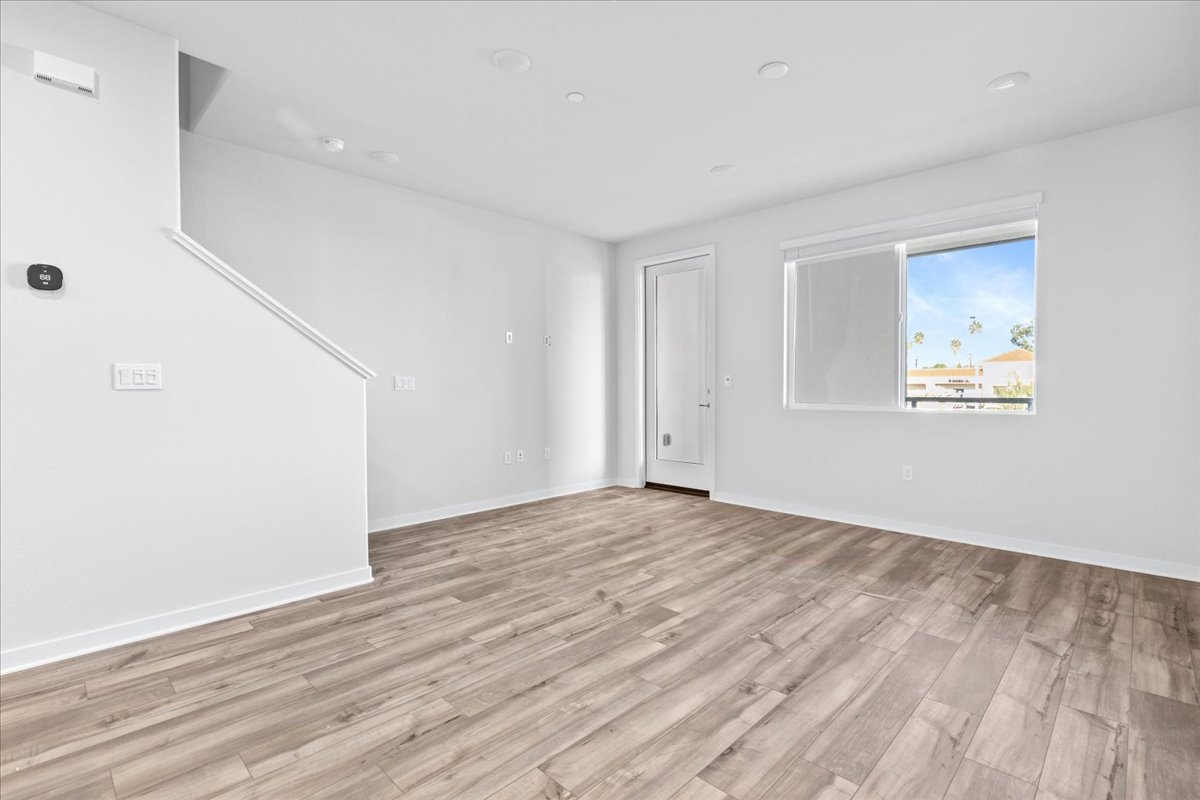 A room with a wood floor and a wood floor with a painting on the wall.