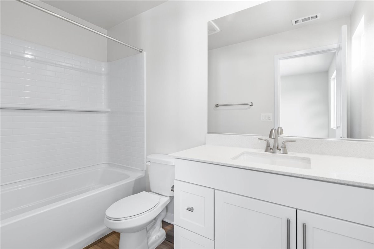 A bathroom with a tub sink and toilet.
