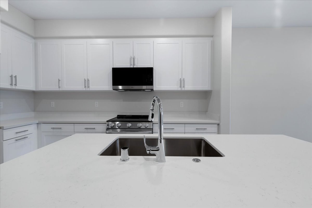 A kitchen with white cabinets.