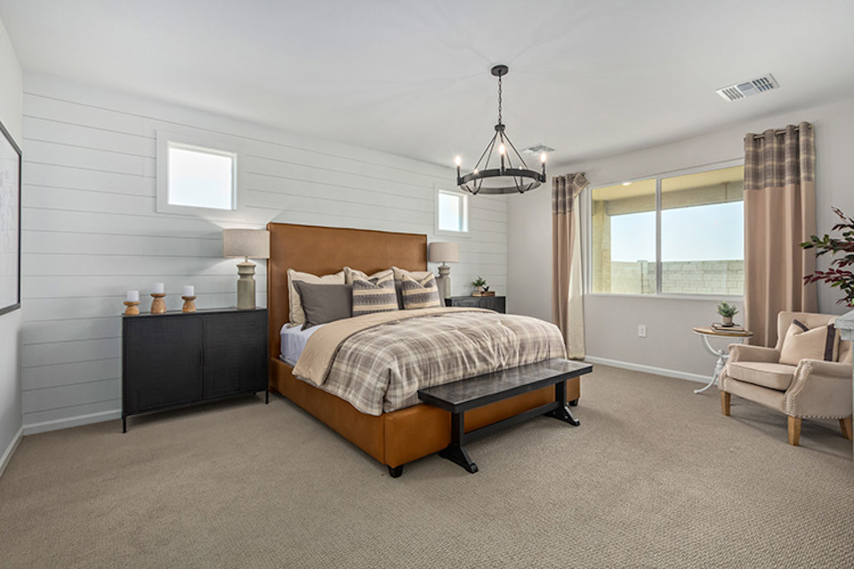 A bedroom with a bed and a chair.