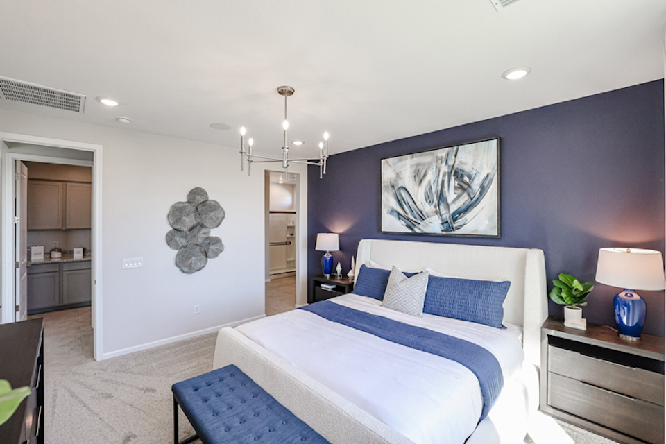 A bedroom with a bed and blue walls.