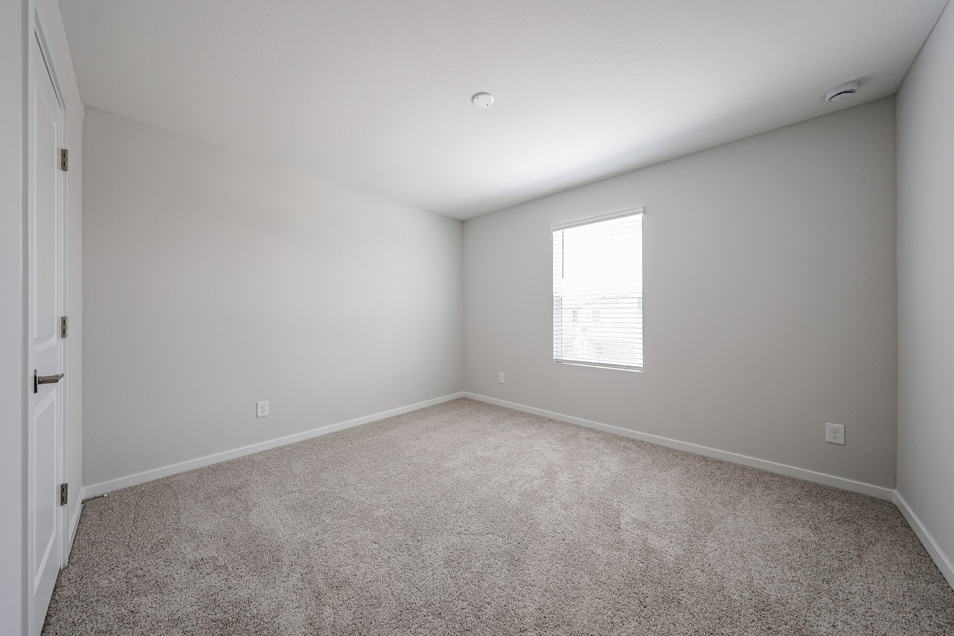 A room with a carpet and a window.