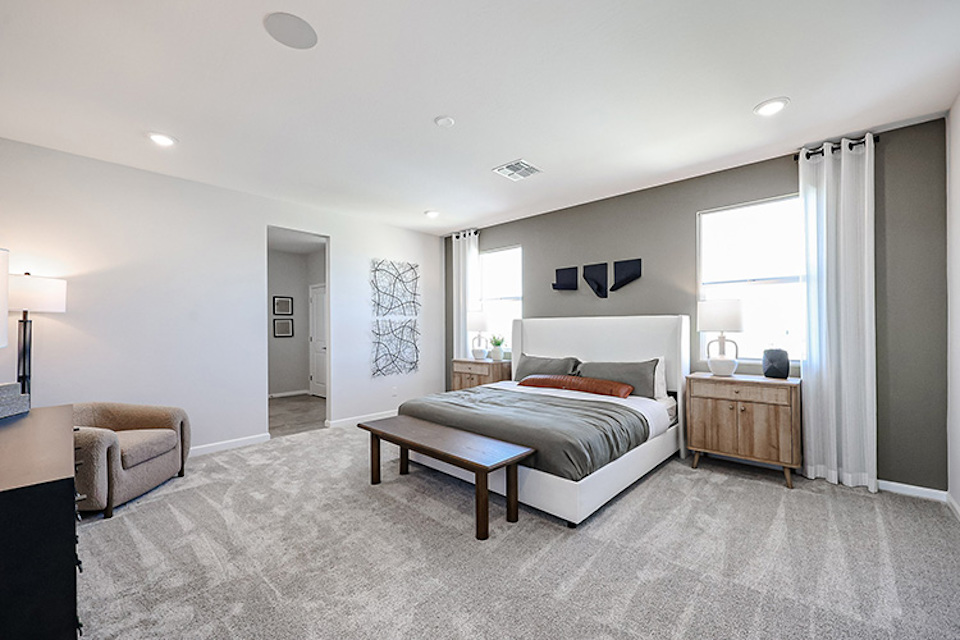 A bedroom with a bed and a bench.