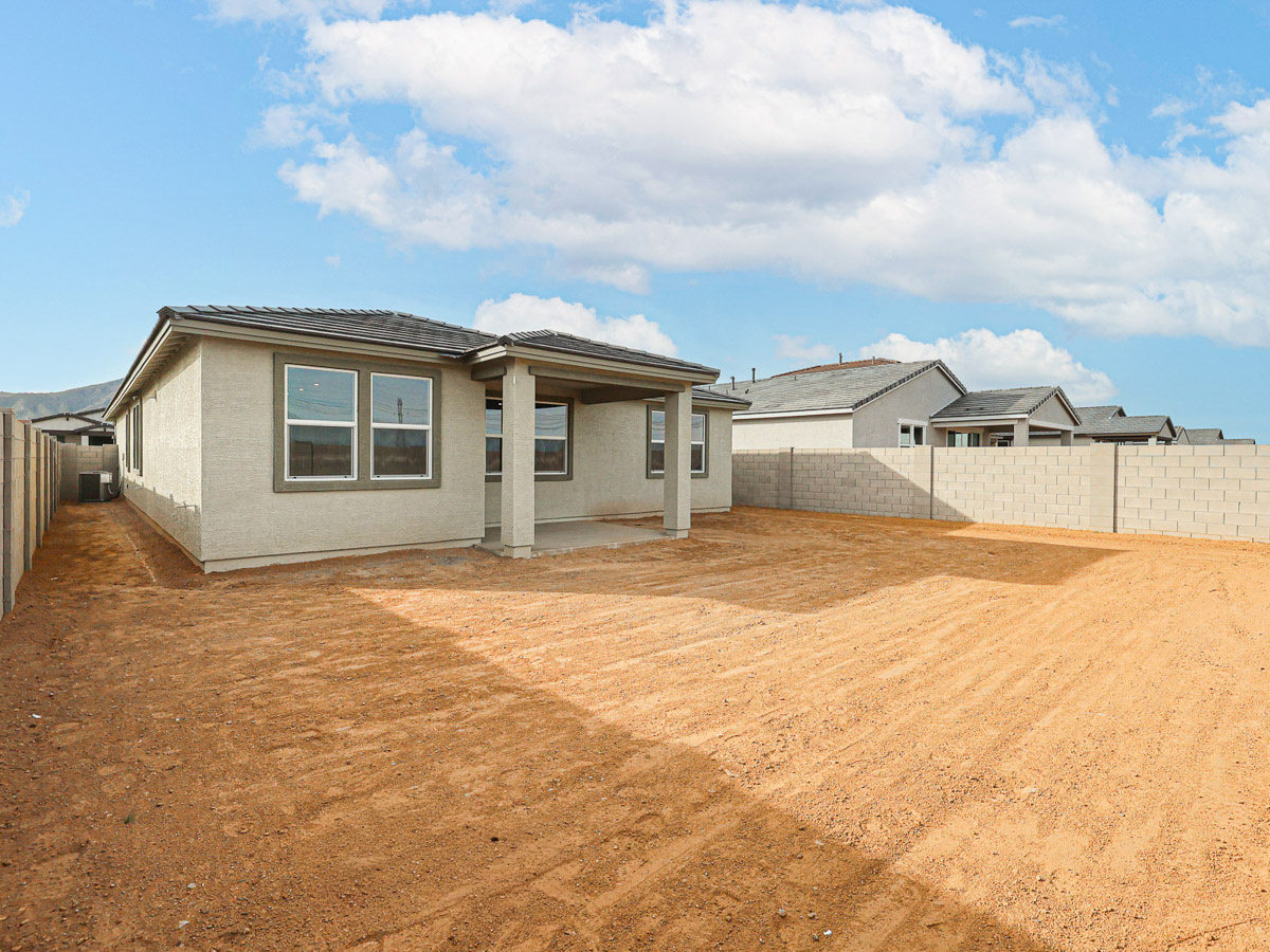 A dirt area with a building in the background.