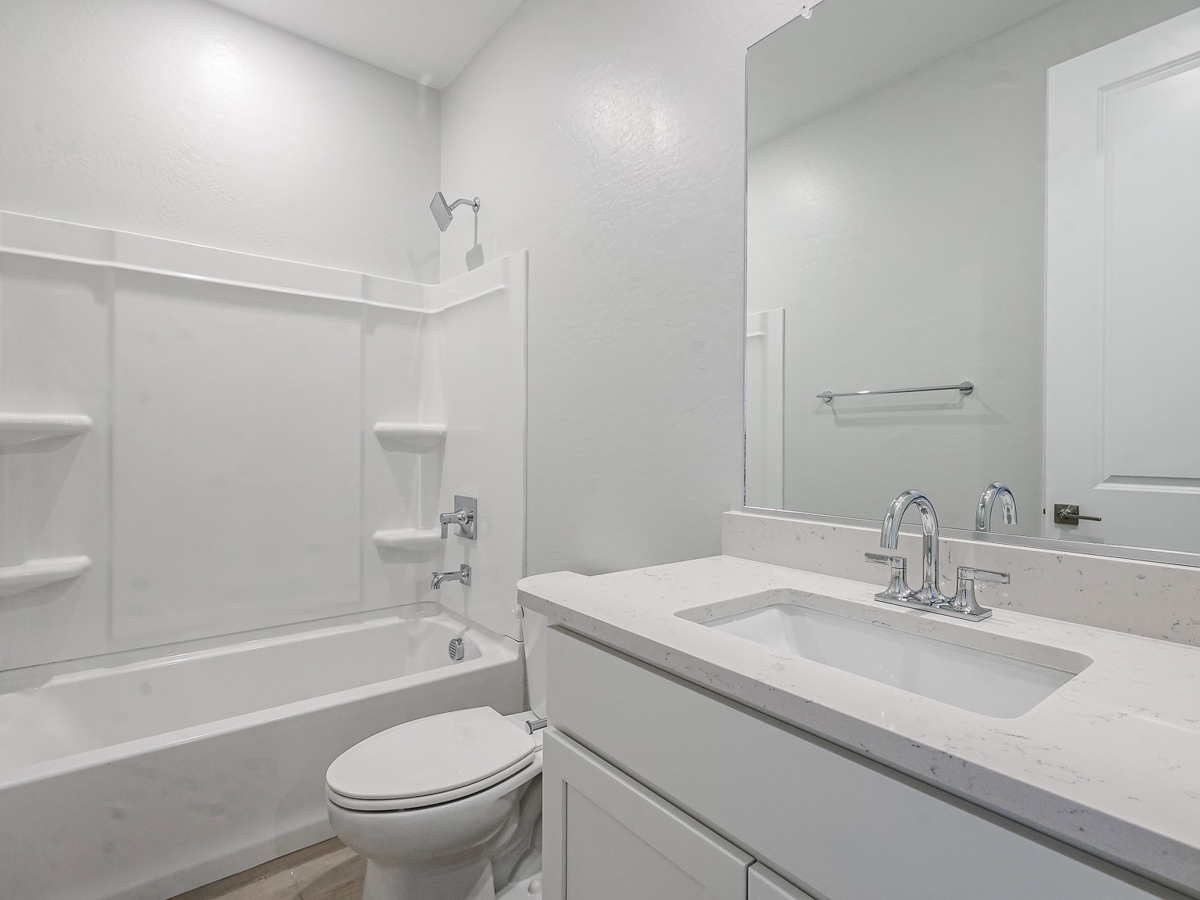 A bathroom with a tub sink and toilet.