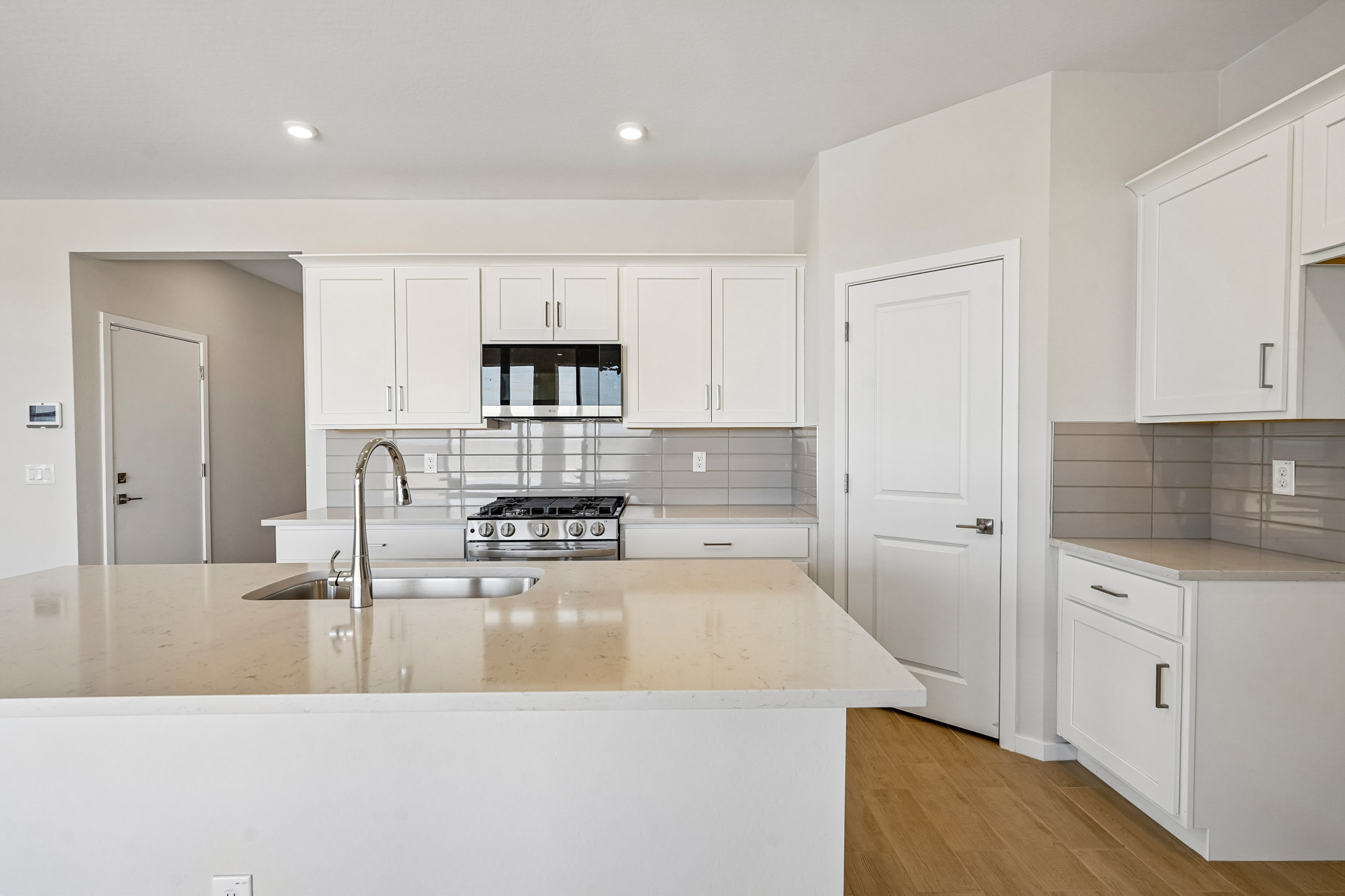 A kitchen with white cabinets.