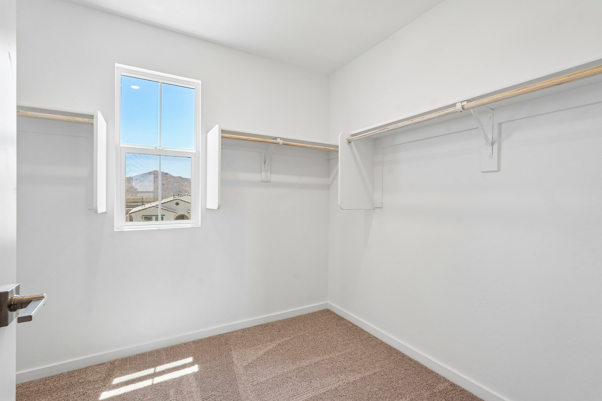 A room with a window and a rug.