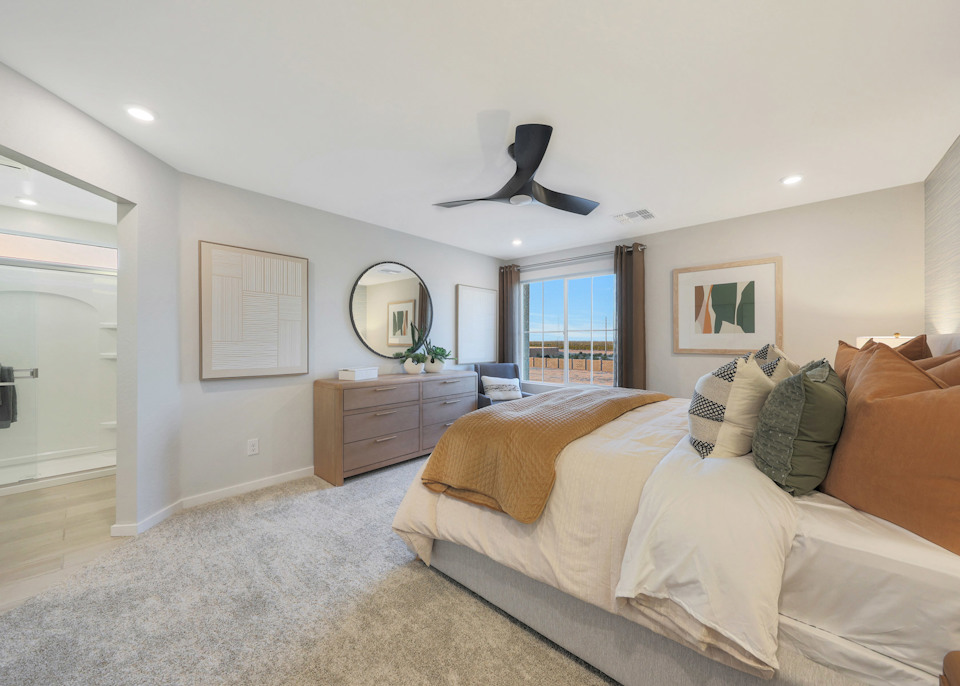 A bedroom with a bed and a fan.