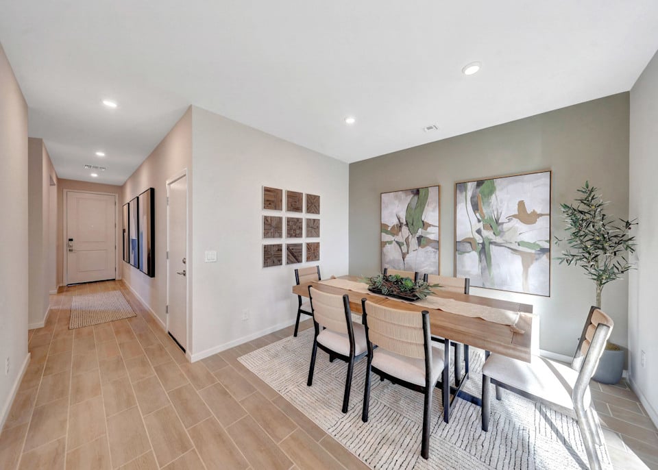 A dining room with a table and chairs.