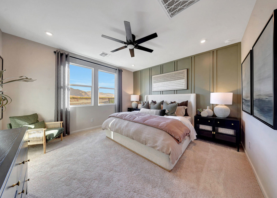 A bedroom with a large bed and a fan.