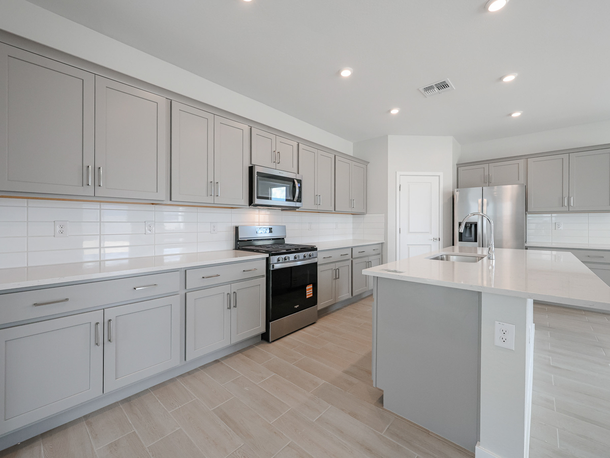 A kitchen with white cabinets.