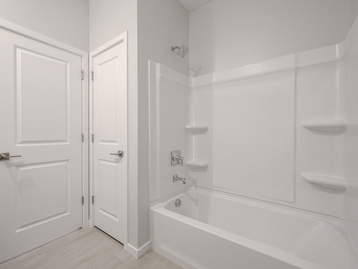 A bathroom with white cabinets.