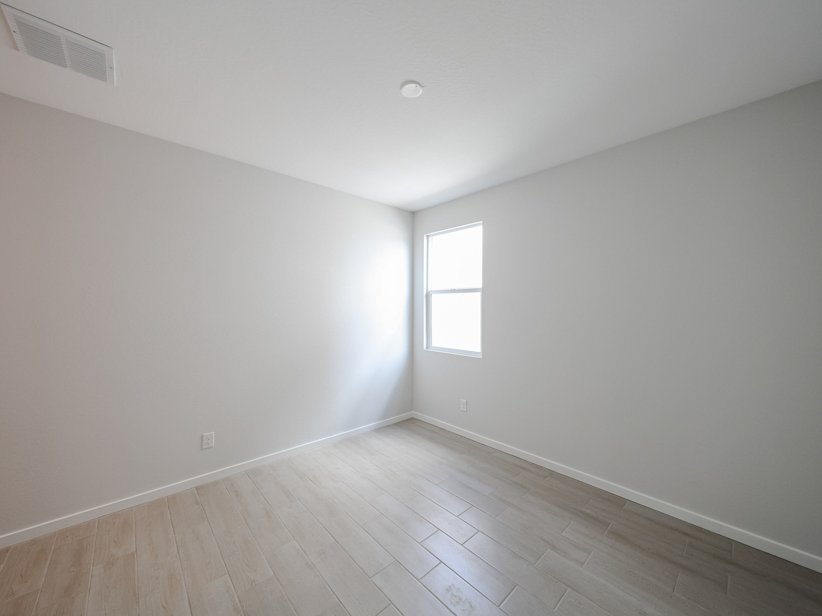 A room with a wood floor and a window.