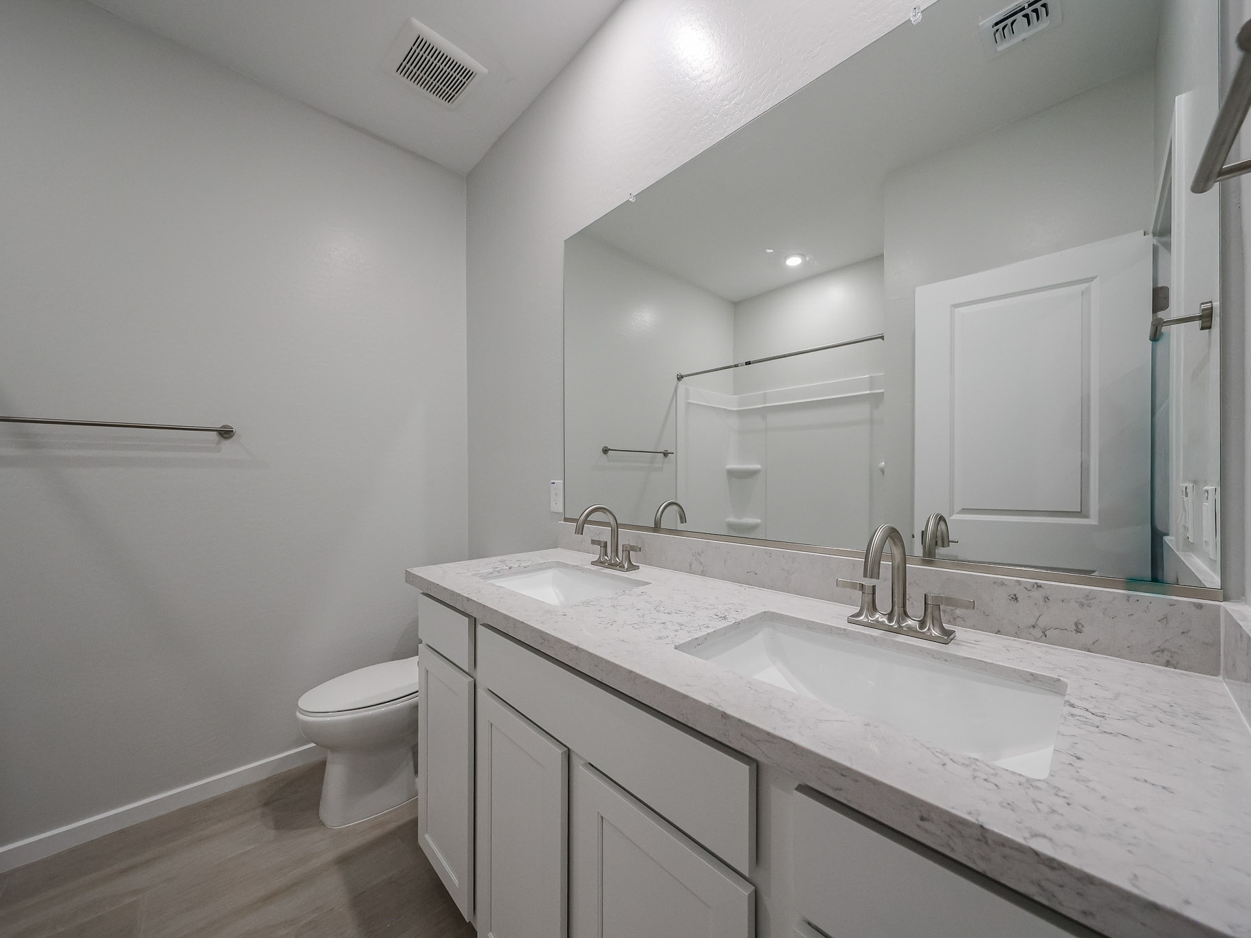 A bathroom with a large mirror.