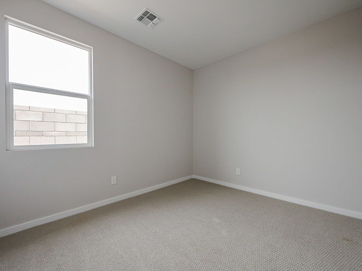 A room with a window and a carpet.