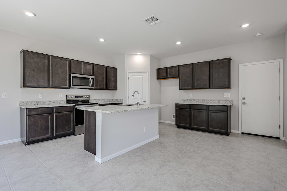 A kitchen with black cabinets.