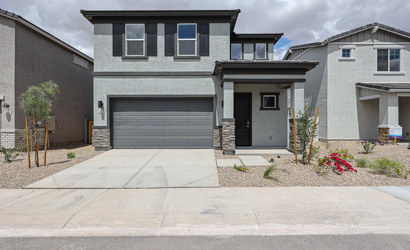 A grey house with garages.