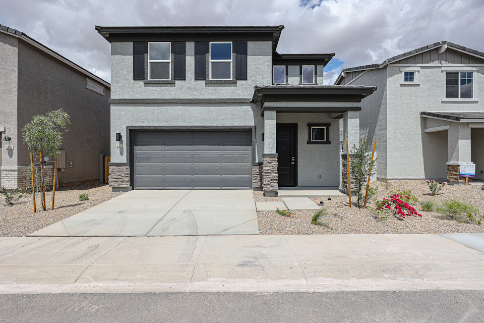 A grey house with garages.